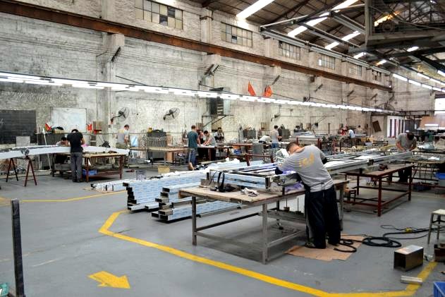 Fitters assembling stainless steel work at benches